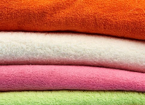 stack of colored cotton terry folded towels, close up