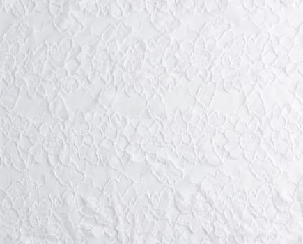 texture of crumpled white synthetic fabric guipure for sewing clothes on a white background, full frame