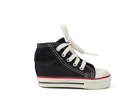 children's black textile sneaker with rubber sole and tied with white laces, white isolated background