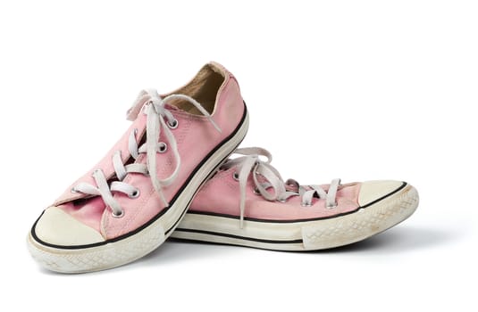 pair of light pink worn textile sneakers with laces isolated on a white background, front view