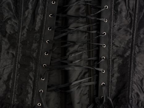 fragment of a black satin corset with lacing, back view, clothing item
