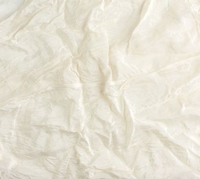 crumpled beige synthetic fabric for the manufacture of lining for skirts, full frame
