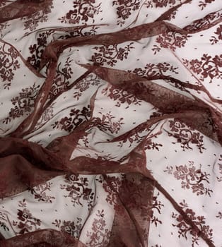 texture of crumpled brown synthetic fabric guipure for sewing clothes on a white background, full frame