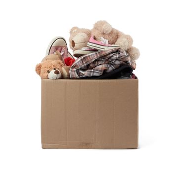 large brown cardboard box filled with things and children's toys, concept of moving, volunteering and help