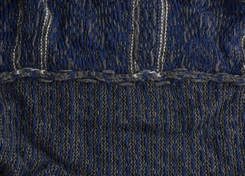 wrong side of gray knitted fabric with a blue pattern, full frame, detail of a woolen scarf