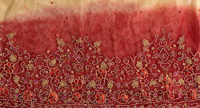 crumpled red yellow tulle with sewn red round sequins and embroidered bead pattern, fabric for sewing clothes, full frame
