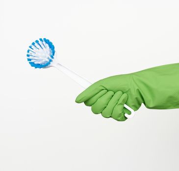 white plastic cleaning brushes in hand, protective green glove on hand, white background