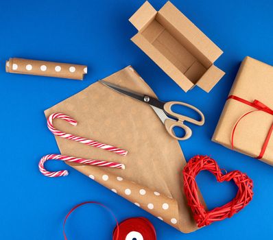 brown kraft paper, packed gift bags and tied with a red ribbon, red heart, set of items for making gifts with your own hands. Gift wrapping. Package design