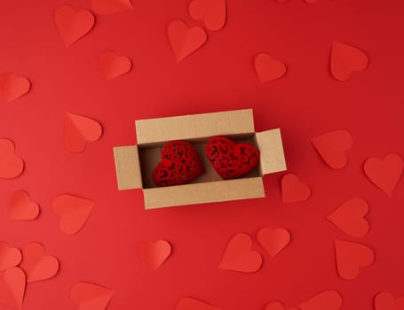 hearts cut out of red paper on a red background, festive backdrop for Valentine's Day, flat lay
