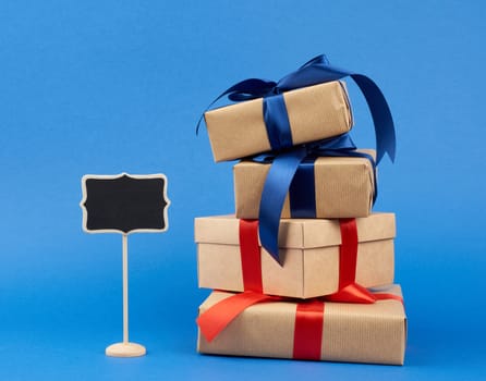 wooden pointer and rectangle box wrapped in brown kraft paper and tied with a silk ribbon, gift on a dark blue background