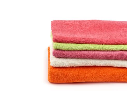 stack of colored cotton terry folded towels on a white background, copy space