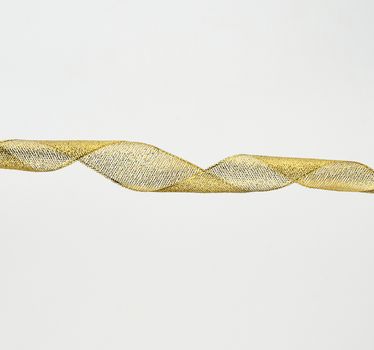 twisted golden silk decorative ribbon for packing gifts on a white background, close up
