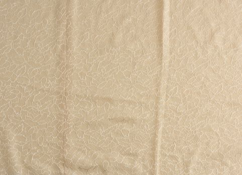 beige satin textile fabric with embroidery elements, piece of canvas for sewing curtains and things, full frame. Crumpled textile satin, great design for any purposes.