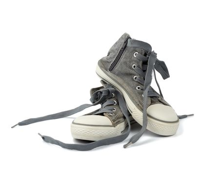 pair of black well-worn, shabby sneakers with black laces isolated on a white background
