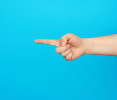 hand shows forefinger gesture on a blue background, close up