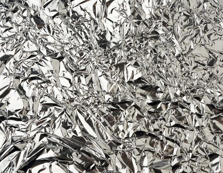 texture of shiny crumpled piece of gray foil, packaging material for food and objects, full frame