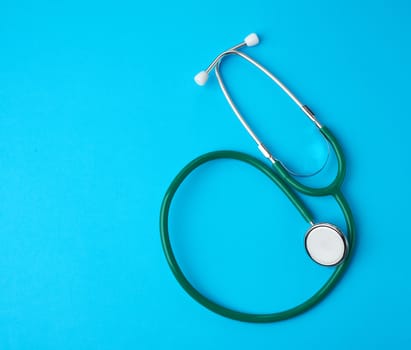green medical stethoscope on a blue background, backdrop for medicine