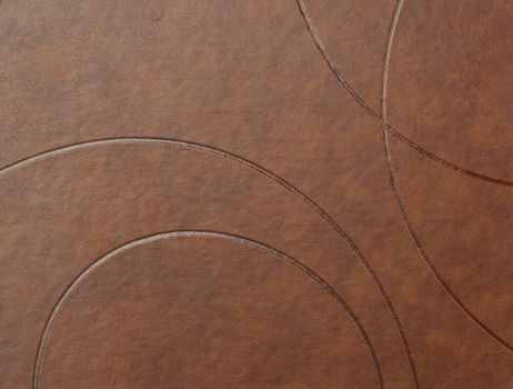 texture of brown leather surface with embossed elements, full frame, close up