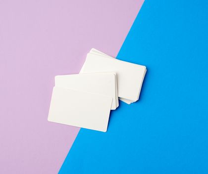 stack of rectangular white blank business cards on a blue background, backdrop for the designer