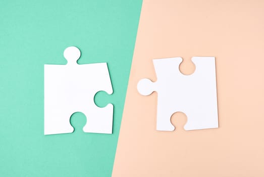 white large blank paper puzzles on a beige green background, top view, copy space