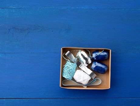 brown cardboard box with a set of decor ribbons for wrapping gifts on a dark blue background, top view