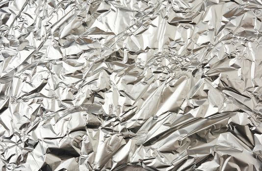 texture of matte crumpled piece of foil, food and objects packaging material, full frame