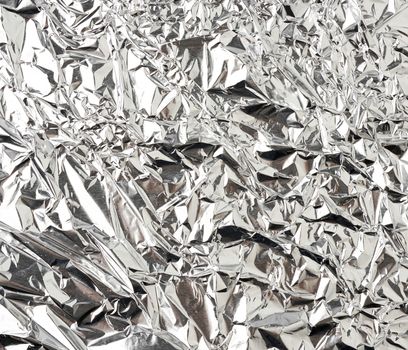 texture of shiny crumpled piece of gray foil, packaging material for food and objects, full frame