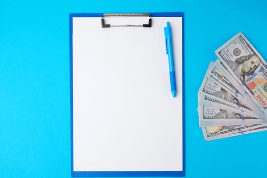blue paper holder with white blank sheets and a stack of paper american dollars, concept of planning and conservation, cash investment
