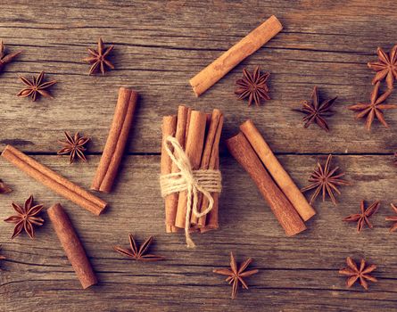 brown cinnamon sticks tied in a bun on a gray wooden background, tasty and fragrant spice, top view