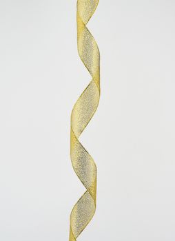 twisted golden silk decorative ribbon for packing gifts on a white background, close up