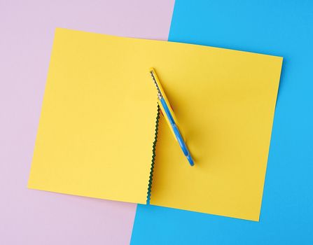 children's scissors cut a yellow sheet of paper, top view