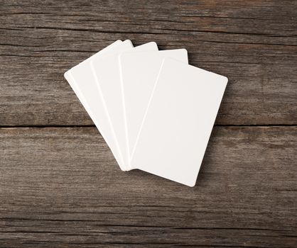 stack of rectangular white blank business cards on a gray wooden background, backdrop for the designer, copy space