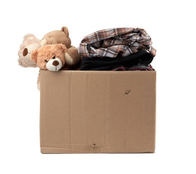 large brown cardboard box filled with things and children's toys, concept of moving, volunteering and help