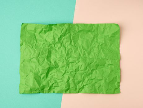 empty crumpled green rectangular sheet of paper a4 on a color background, copy space