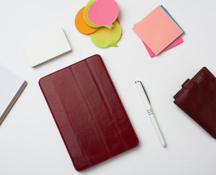 open paper notebooks and pen, brown wallet on a white table, freelancer workplace, top view