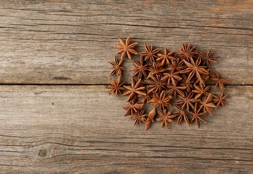 fragrant anise star anise on a gray wooden background from boards, top view, copy space