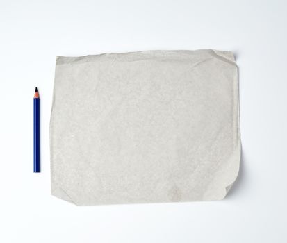 empty gray crumpled sheet of paper and blue wooden pencil, close up
