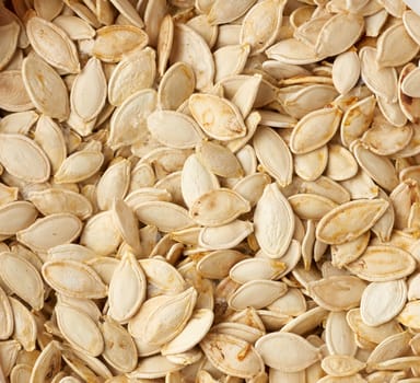 dry raw unpeeled pumpkin seeds, full frame, close up