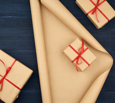 brown kraft paper, packed gift boxes and tied with a red ribbon, set of items for making gifts. Gift wrapping. Package design, copy space