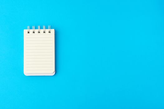 open blank notebook in line on a blue background, copy space