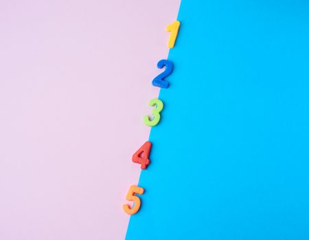multi-colored plastic children`s figures on a colored background, flat lay, copy space