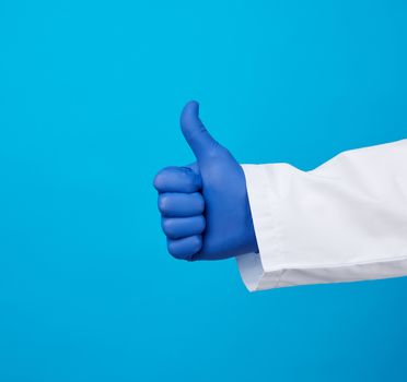doctor in a white coat shows with his hand a gesture like, wearing blue latex medical gloves, close up