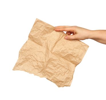 hand holds a crumpled brown sheet of parchment paper, subject is isolated on a white background