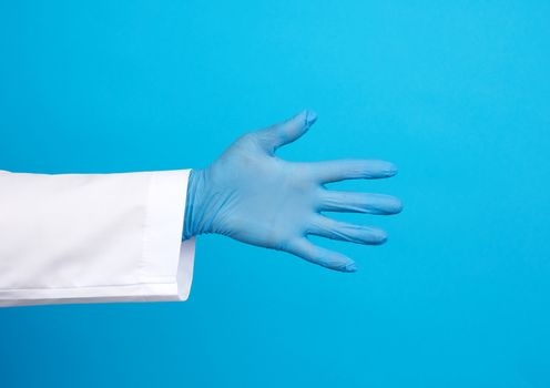 medic in a white coat, blue latex gloves pulls his hand for a handshake on a blue background