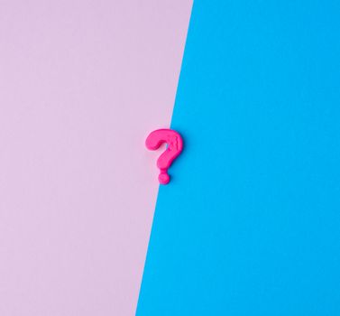 plastic question mark on a colored background, abstract backdrop, close up
