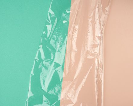 texture of a transparent stretching plastic film for packaging products on a green beige background, full frame,copy space