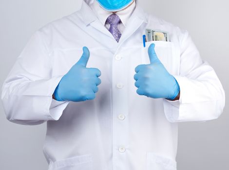 doctor in a white coat and tie shows with his hand a gesture like, wearing blue latex medical gloves, close up
