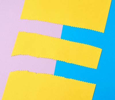 abstract background of colored paper, yellow stripes with a zigzag end, top view