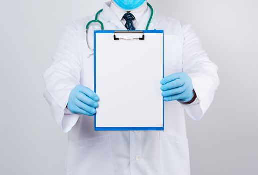 male doctor in a white coat, blue latex gloves, a stethoscope hanging on his neck, doctor holding a paper holder with a white blank sheet, place for writing a prescription and text