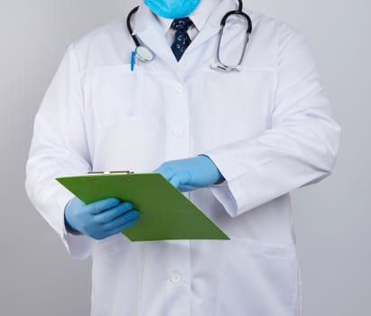 doctor in a white coat, blue latex gloves,  stethoscope hanging on his neck, he holding a paper clipboard 